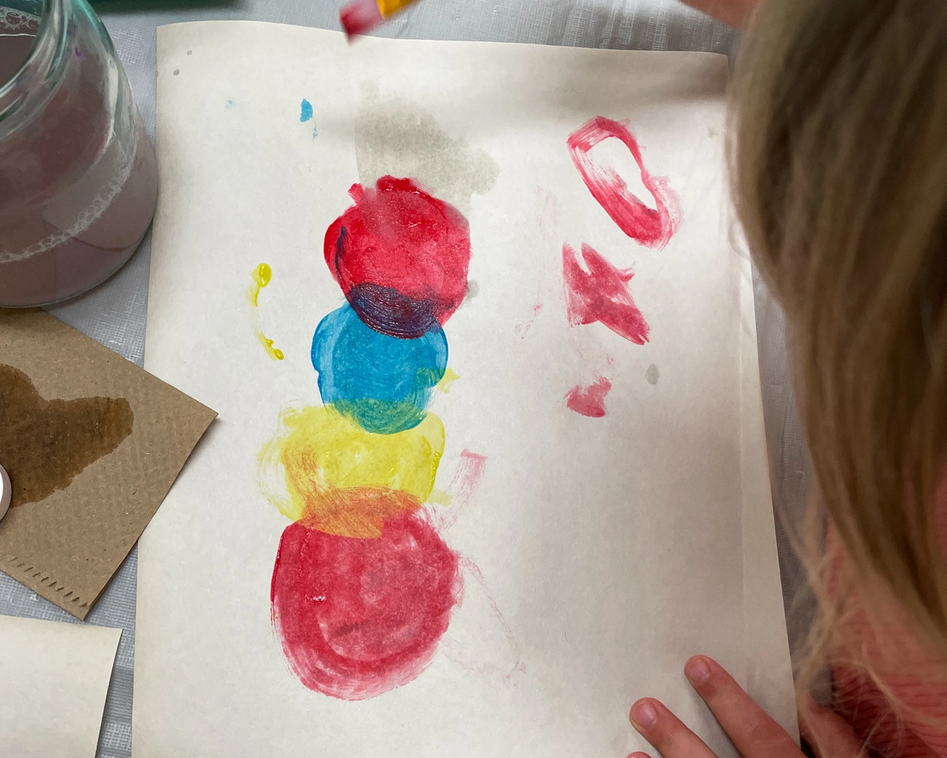 Preschool children painting together at a table, exploring colors and creativity. Preschool and After school Care in Cochrane AB